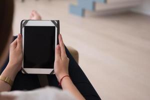 woman sitting on sofa with tablet computer photo