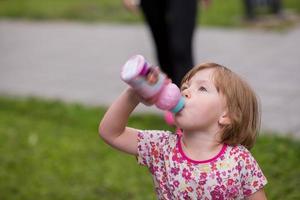 little girl drinking fresh water photo