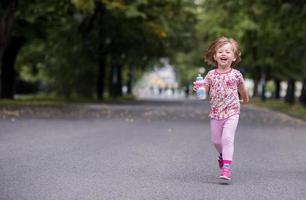 little girl drinking fresh water photo