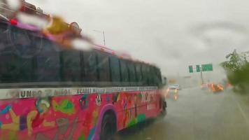 Playa del Carmen Quintana Roo Mexico 2022 Pink Xcaret bus drives in heavy rain on highway Mexico.