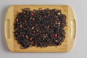 Dry tea based on black with pieces of passion fruit on a wooden background. photo