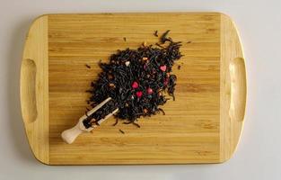 Dry tea based on black with pieces of passion fruit on a wooden background. photo