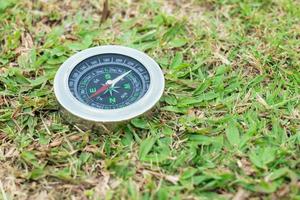 The compass is placed on the green grass showing north south  east west photo