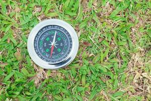 The compass is placed on the green grass showing north south  east west photo