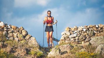 A sporty young woman with trekking sticks photo