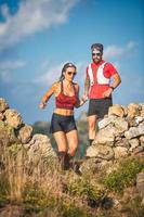 A personal trainer takes his client for a run in the hills photo