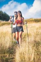 pareja joven durante una caminata de marcha nórdica foto