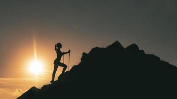 Woman climbs among rocks in a colorful mountain sunset photo