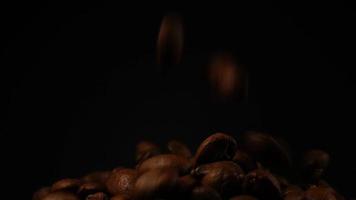 câmera lenta de grãos de café torrados caindo. sementes de café orgânico. video