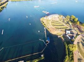 Beautiful Aerial Drone's Camera  Footage of Willen Lake and Park which is located at Milton Keynes, England. People are Enjoying at Lake on a Hot Sunny Day of Summer photo