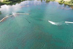 Beautiful Aerial Drone's Camera  Footage of Willen Lake and Park which is located at Milton Keynes, England. People are Enjoying at Lake on a Hot Sunny Day of Summer photo