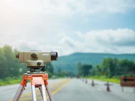 Surveyor equipment tacheometer or theodolite with road construction site background photo