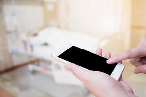 Hand hold mobile phone with abstract hospital room interior photo