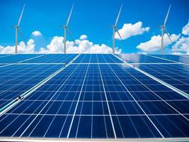 paneles solares y turbinas de viento con las nubes y el cielo foto