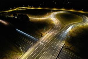 Night Aerial View of British Motorways with illuminated Roads and Traffic. Highways footage taken with drone's camera over Milton Keynes and motorways of England at Dark Night photo