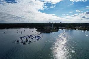 bellas imágenes de la cámara de drones aéreos del lago y parque willen que se encuentra en milton keynes, inglaterra. la gente está disfrutando en el lago en un caluroso día soleado de verano foto