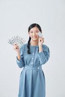 retrato de una hermosa mujer asiática con tarjeta de crédito y papel moneda, concepto de venta foto