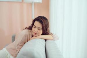 Tired attractive woman taking a nap on a sofa, close up of her face photo