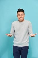 Young happy handsome Asian man raising his hands with open palms gesture photo