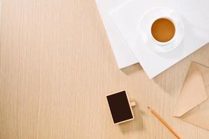 Flat lay of coffee cup, clock, pencil and a notebook. photo