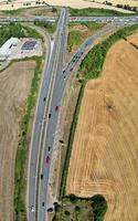 hermosa vista aérea de las concurridas autopistas británicas con tráfico y ciudad en un día soleado foto