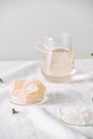 Aromatherapy. Small glass bottles with cosmetic oils. Bath salt. Fresh leaf. Objects for spa procedures on white background oil, leaf. photo