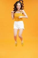 young pretty teenage girl jumping cheerful isolated on yellow background, lifestyle people concept photo