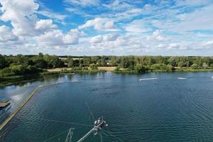 Beautiful Aerial Drone's Camera  Footage of Willen Lake and Park which is located at Milton Keynes, England. People are Enjoying at Lake on a Hot Sunny Day of Summer photo