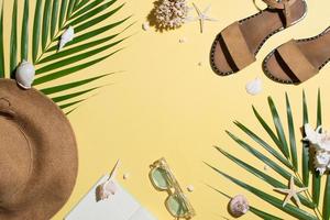 Leather sandals, tropical palm leaves, seashells, starfish on white background. Summer backdrop.