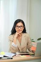 Young female gardener in glasses using laptop, communicates on internet with customer in home photo