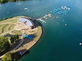 bellas imágenes de la cámara de drones aéreos del lago y parque willen que se encuentra en milton keynes, inglaterra. la gente está disfrutando en el lago en un caluroso día soleado de verano foto