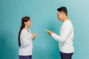 amazing couple whose use smart phone read news look with interest isolated light blue background photo