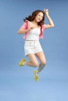 Happiness, freedom, movement and people concept - smiling young woman jumping in air. photo