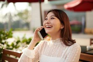 Happy young travel asian woman talking with mobile phone and relax photo