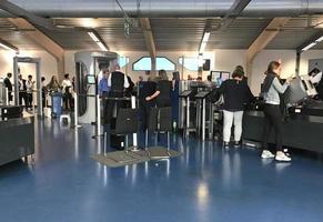 Barcelona, Spain, 2019 - Passengers line up at the security check of Barcelona's airport while a security guard watches the scene photo