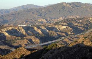 A highway going through the Californian scenery near Valencia, CA photo