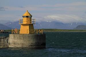 Reykjavik, Iceland, 2019 - Yellow light house at the harbor of Reykjavik, Iceland photo