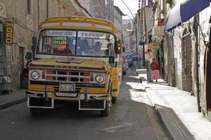 La Paz, Bolivia, 2018 - A bus works its way through the narrow streets of La Paz, Bolivia, on a sunny day. photo