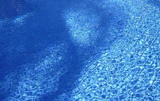 Ripples on the surface of an outdoor pool on a sunny day photo