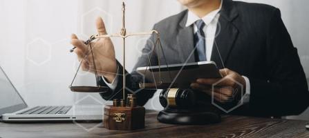 Justice and law concept.Male judge in a courtroom with the gavel, working with, computer and docking keyboard, eyeglasses, on table in morning light photo