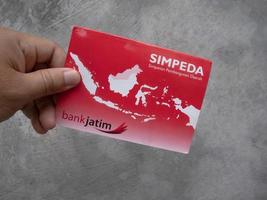 Sidoarjo, Jawa timur, Indonesia, 2022 - a man holding a bank passbook in his hand photo