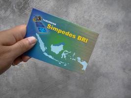 Sidoarjo, Jawa timur, Indonesia, 2022 -  a man holding a simpedes bri bank passbook photo