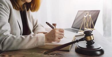 Business and lawyers discussing contract papers with brass scale on desk in office. Law, legal services, advice, justice and law concept picture with film grain effect photo