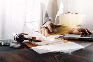 Business and lawyers discussing contract papers with brass scale on desk in office. Law, legal services, advice, justice and law concept picture with film grain effect photo