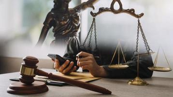 Male lawyer working with contract papers and wooden gavel on tabel in courtroom. justice and law ,attorney, court judge, concept. photo