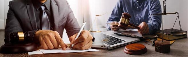 Justice and law concept. Gavel on sounding block in hand's Male judge at a courtroom, working with document law books, report the case on table in modern office. photo