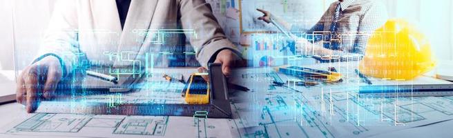 Dos colegas discutiendo el trabajo de datos y una tableta, un portátil con un proyecto arquitectónico en el sitio de construcción en un escritorio en la oficina foto