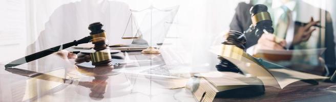 Justice and law concept. Gavel on sounding block in hand's Male judge at a courtroom, working with document law books, report the case on table in modern office. photo