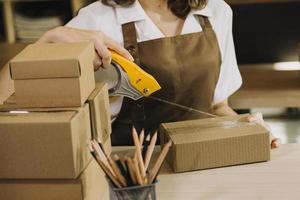 Portrait of Starting small businesses SME owners, two Asian woman check online orders Selling products working with boxs freelance work at home office, sme business online small medium enterprise photo