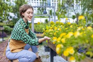 Caucasian garden owner is tending to her ornamental flower plant at nursery garden center for native and exotic plant grower concept photo